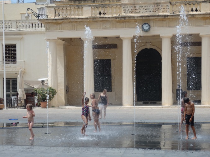 Kids playing in the Spring Water in Front of the Palace, Valletta, Malta